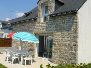 stół i krzesła z parasolem przed domem w obiekcie SALINES - Maison entre ville et plages - K190 w mieście Carnac