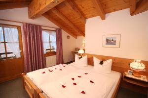 a bedroom with a bed with roses on it at Landhaus Aigner-Vogler in Fischen