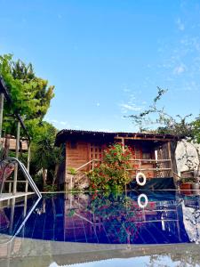 a house with a pool in front of a building at Deep Ocean Camping-Adults Only in Faralya