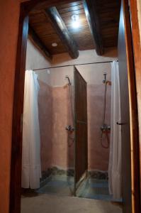 a bathroom with a shower with a glass door at KONDUR ELEMENTOS ECO HOSTEL in Las Compuertas