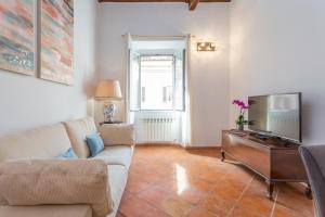 a living room with a couch and a tv at Barberini 3 BDR Apartment in Rome