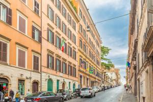 a city street with parked cars and buildings at Barberini 3 BDR Apartment in Rome