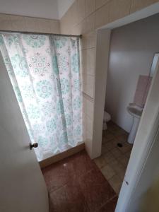 a bathroom with a shower curtain and a toilet at Cabañas Larache in San Pedro de Atacama
