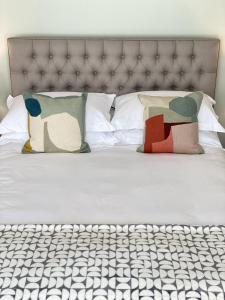 uma cama com almofadas com lençóis brancos em Spacious, seaside, Victorian home "Bay View Terrace", Penzance em Penzance