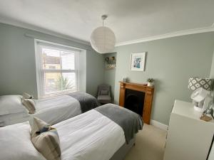 a bedroom with two beds and a fireplace at Spacious, seaside, Victorian home "Bay View Terrace", Penzance in Penzance
