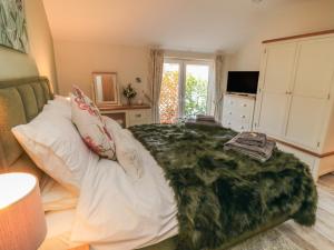 a bedroom with a bed with a green blanket on it at Garthgate Holiday Lodge in Malton