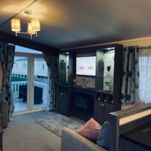 een woonkamer met een bank en een flatscreen-tv bij Crimdon dean park in Horden