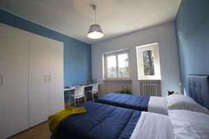 a blue bedroom with two beds and a table at Dreams Hotel Residenza Gambara in Milan