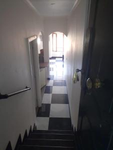 a hallway with a staircase with a door and a checkerboard floor at "Magnifique appartement" Vue Mer, Rénové, Plage in Menton