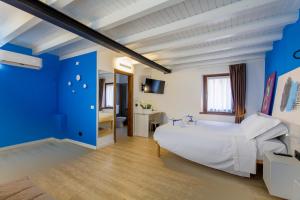 1 dormitorio con 1 cama blanca grande y paredes azules en Le Tofane, vivi la bellezza di Belluno - Genziana, en Sòis