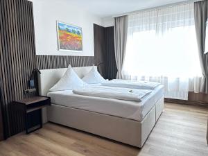 Schlafzimmer mit einem großen weißen Bett und einem Fenster in der Unterkunft Hotel Bilger Eck in Konstanz