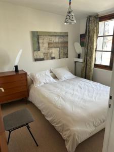 - une chambre avec un lit blanc, une commode et une fenêtre dans l'établissement Superbe T4 vue mer à Royan, 2 min à pied des plages, à Royan