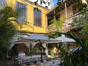 a patio with tables and umbrellas in front of a building at Casa Montesdeoca - Jacaranda in Las Palmas de Gran Canaria