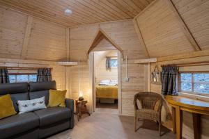 ein Wohnzimmer mit Sofa und ein Schlafzimmer in der Unterkunft Cairngorm Bothies in Aboyne
