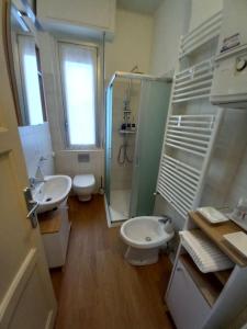 a bathroom with two sinks and a shower and a toilet at Ossola Bella la tua casa in Domodossola