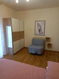 a bedroom with a bed and a chair in it at Ossola Bella la tua casa in Domodossola