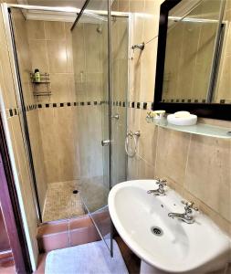 a bathroom with a sink and a shower at Guesthouse Private Room with Garden and Pool in Gaborone