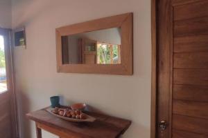 einen Spiegel an einer Wand mit einer Schüssel auf einem Tisch in der Unterkunft Cabaña Azul, Cabañas Vacacional el Porvenir in San Antero