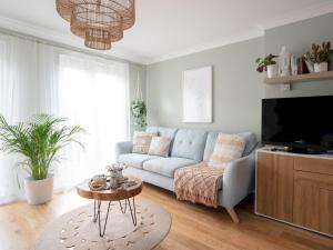 a living room with a couch and a tv at Historic Malmesbury - Delightful home with parking in Malmesbury