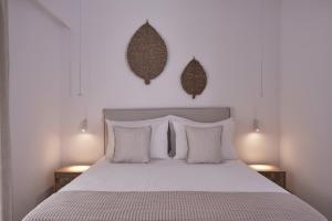 a bedroom with a bed with white sheets and pillows at Isida Andros in Agios Petros