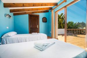 two beds in a room with a balcony at Villa Cintya - PlusHolidays in Ifach +22 photos