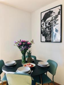 a dining room table with chairs and a vase of flowers at oompH Warsaw Downtown Apartments in Warsaw