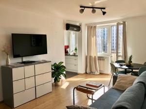 a living room with a couch and a flat screen tv at oompH Warsaw Downtown Apartments in Warsaw