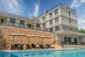 a hotel with a swimming pool and umbrellas at Phoenix Apartment by LINK in Kigali