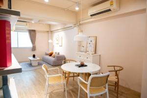 2BR minimal mu-ji style 130SQM ~ في Makkasan: غرفة معيشة مع طاولة وكراسي وأريكة