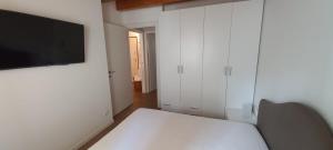 Habitación con cama y TV en la pared. en Villaggio delle Alpi en Pré-Saint-Didier