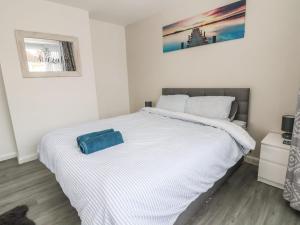 a white bed with a blue bag on top of it at Sea La Vie in Rhyl