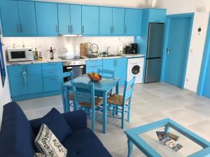 una cocina con armarios azules y una mesa y sillas azules en UTOPIA RESIDENCES Gaia House, en Petrokefálion