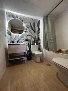 a bathroom with a toilet and a sink and a mirror at Vivienda Oasis Murcia in Churra