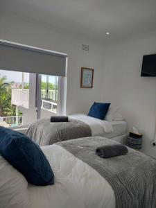 um quarto com três camas com almofadas azuis em Harbour View House em Durban