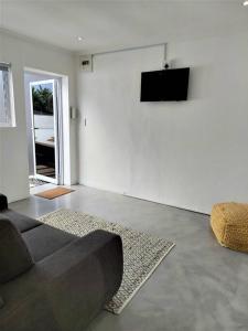 ein Wohnzimmer mit einem Sofa und einem TV an der Wand in der Unterkunft Harbour View House in Durban