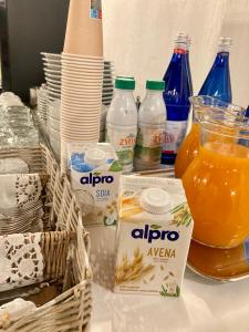 una mesa con botellas de leche y un vaso de zumo de naranja en Hotel Livio, en Brescia