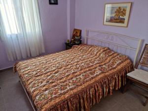 ein Schlafzimmer mit einem Bett mit einer Decke darauf in der Unterkunft Giannis country house in Palaiokómi
