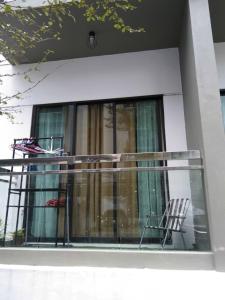 a balcony with a chair and a window at IMAN HOMESTAY : PRIMA HOMES MATANG APARTMENT in Kampung Gita