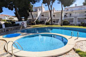 a swimming pool in front of a building at Bella Brisa, Port d'Addaia in Port d'Addaia