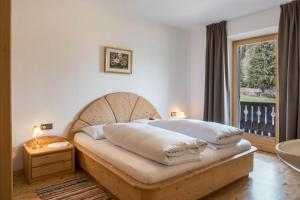 a bedroom with a bed with a wooden headboard and a window at Adlerhorst Blaumeise in Santa Valpurga