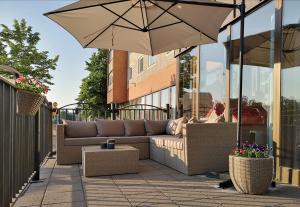patio con divano e ombrellone di Comfort Hotel Eskilstuna a Eskilstuna
