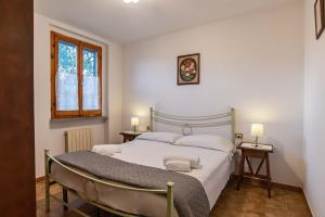 Un dormitorio con una gran cama blanca y una ventana en Residenza di Campagna Montelleri, en Vicchio