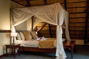 1 dormitorio con 1 cama con dosel en The Victoria Falls Waterfront, en Livingstone