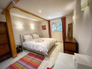 1 dormitorio con cama blanca y ventana en Appartement au calme avec terrasse verdoyante entre Annecy et Genève, en Villy-le-Pelloux