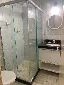 a bathroom with a glass shower with a toilet and a sink at Hotel Victory flat in Cabedelo +4 photos