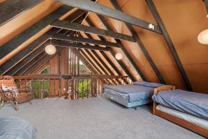 a attic room with two beds and a ladder at Bremner Lodge - Wanaka Holiday Home in Wanaka