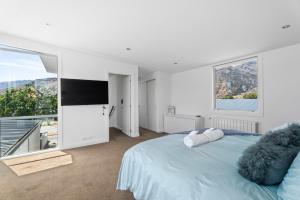 a bedroom with a large bed and a large window at Heavenly on Hope - Lake Hayes Holiday Home in Queenstown