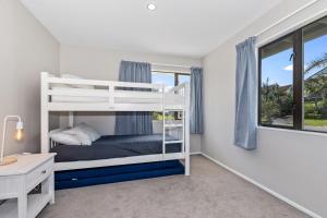 Un dormitorio con dos literas y un escritorio. en Retreat at Tapeka Point - Russell Holiday Home, en Russell