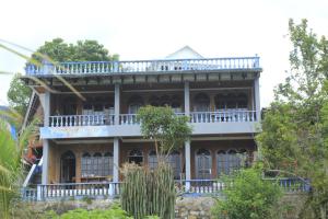 a large house with a balcony on top of it at SONY COTTAGE in Tuk Tuk