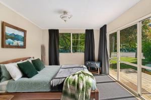 una camera con letto e ampie finestre di Kent Cottage - Arrowtown Holiday Home ad Arrowtown